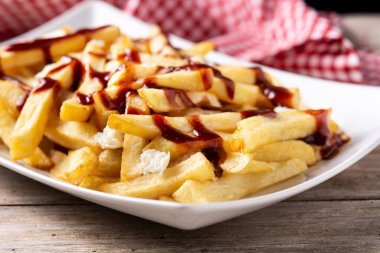 Geleneksel Kanada Poutine 'i ahşap masada