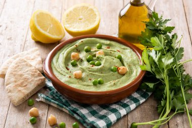 Yeşil bezelye humusu ve ahşap masada pide ekmeği