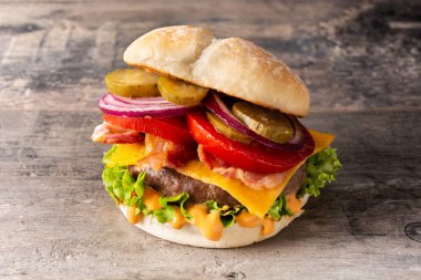 Peynirli sığır burger ve ahşap masada pastırma.