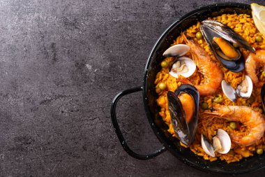 Siyah arka planda geleneksel İspanyol deniz ürünleri paella 'sı. Üst Manzara. Boşluğu kopyala