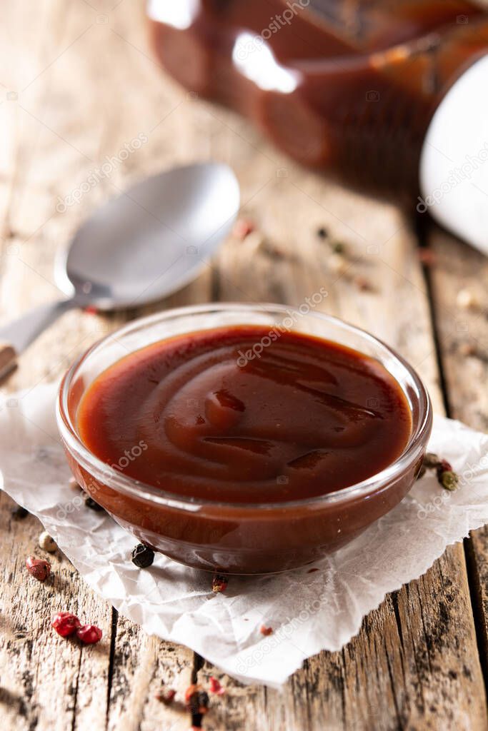 Barbecue sauce in bowl on rustic wooden table