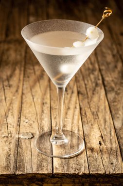 Gibson martini cocktail with onions on wooden table clipart
