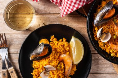 Geleneksel İspanyol deniz ürünleri paella 'sı ahşap masada. Üst görünüm