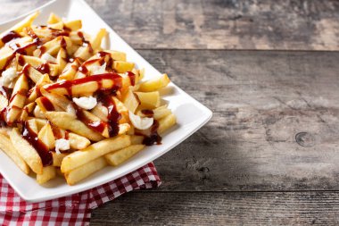 Geleneksel Kanada Poutine 'i ahşap masada. Boşluğu kopyala