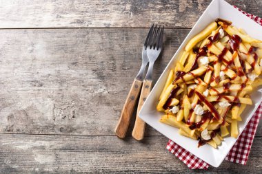 Geleneksel Kanada Poutine 'i ahşap masada. Üst Manzara. Boşluğu kopyala