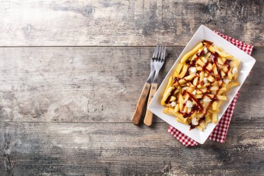 Geleneksel Kanada Poutine 'i ahşap masada. Üst Manzara. Boşluğu kopyala