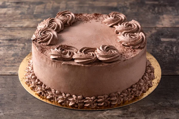 Piece of chocolate truffle cake on rustic wooden table