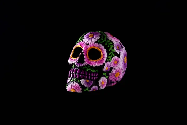 Typical Mexican skull floating in the air on black background