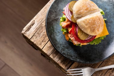 Köy ahşap masada peynirli ve pastırmalı sığır burger.