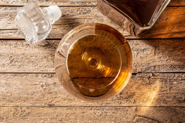 纯朴的木桌和黑色背景的白兰地或威士忌饮料 — 图库照片