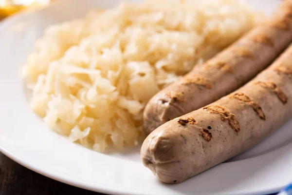 Bratwurst Und Sauerkraut Auf Dem Holztisch Nahaufnahme — Stockfoto