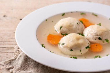 Geleneksel Yahudi matza topu çorbası ahşap masada. Kapat.