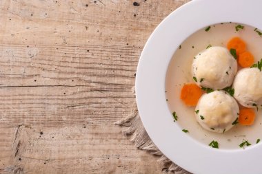 Geleneksel Yahudi matza topu çorbası ahşap masada.