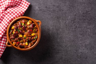 Geleneksel Meksikalı Tex Mex Chili con Carne siyah arka planda bir kasede. Süper manzara. Boşluğu kopyala