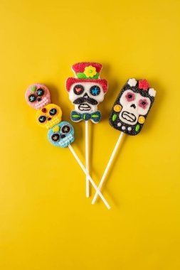 Sarı arka planda şeker kafatası lolipopları