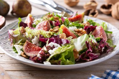 Peynirli incir salatası ve ahşap masada ceviz.