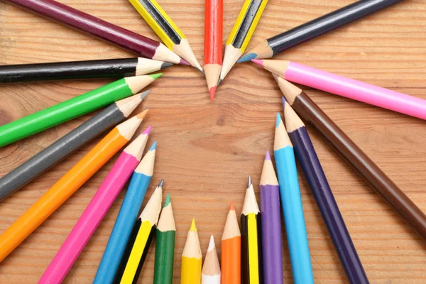 Lápices de colores sobre madera con forma de corazón — Foto de Stock
