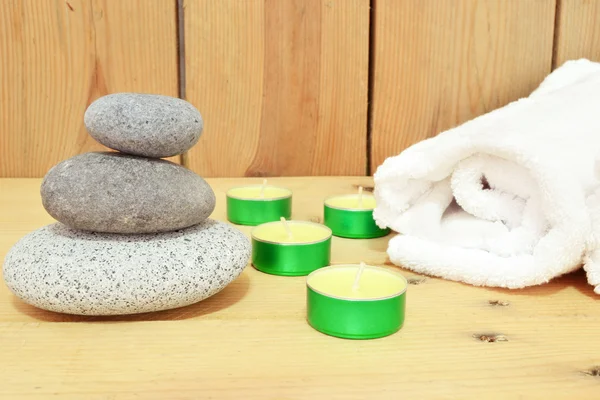 Svíčky, zen kameny a ručník na dřevo — Stock fotografie