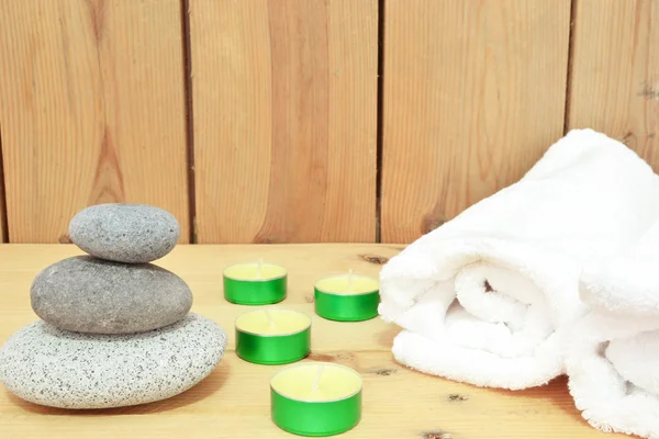 Velas, piedras zen y toalla sobre madera — Foto de Stock