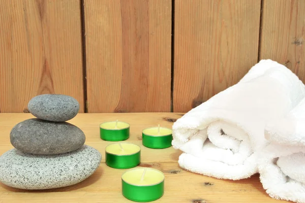 Svíčky, zen kameny a ručník na dřevo — Stock fotografie