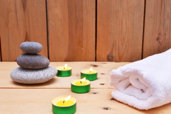 Candles, zen stones and towel on wood — Stock Photo, Image