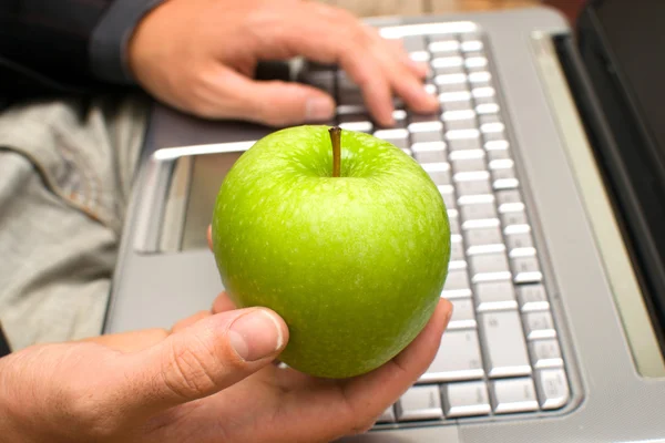 Affärsman med en dator och ett äpple i handen — Stockfoto
