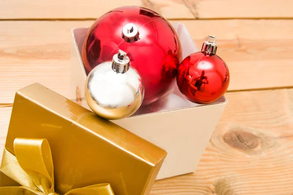 Kerstballen en gift op hout achtergrond — Stockfoto