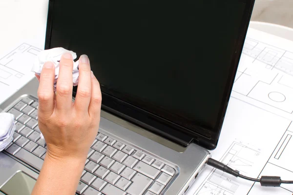 Kvinna med en boll av papper i handen vid datorn — Stockfoto
