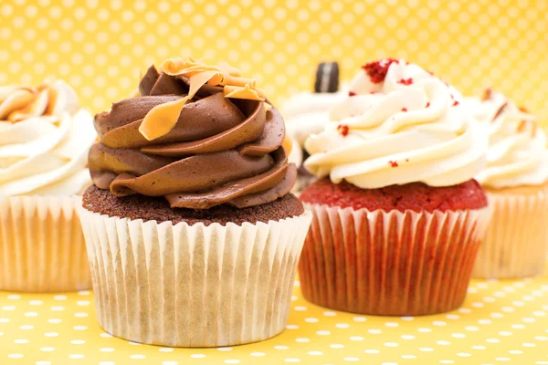 Cupcakes on yellow polka dot background — Stock Photo, Image