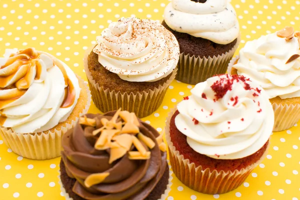 Cupcakes on yellow polka dot background — Stock Photo, Image