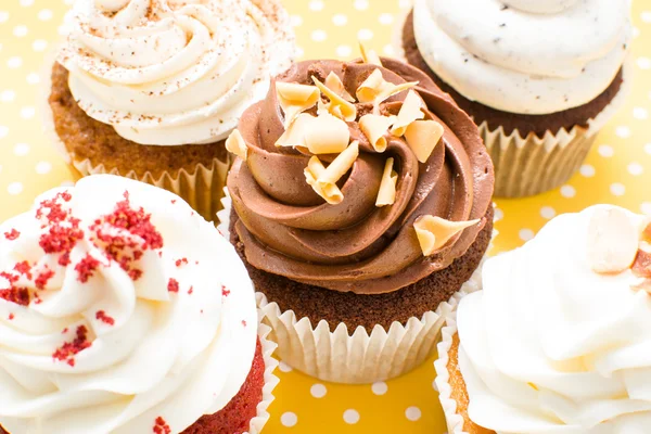 Cupcakes on yellow polka dot background — Stock Photo, Image