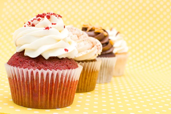 Cupcakes on yellow polka dot background — Stock Photo, Image