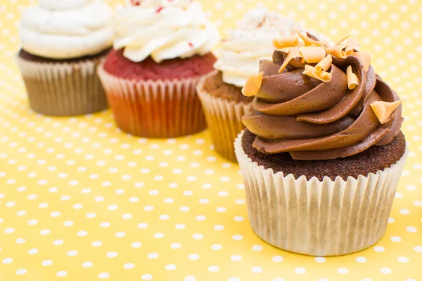 Cupcakes on yellow polka dot background — Stock Photo, Image