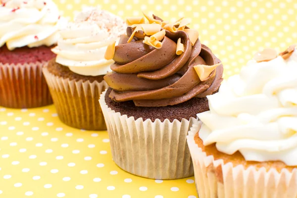 Cupcakes on yellow polka dot background — Stock Photo, Image