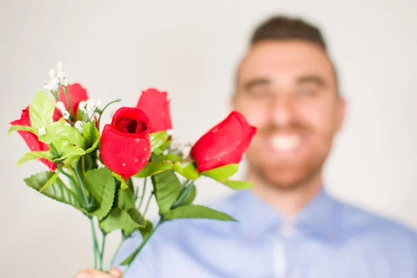 バラの花束を与える若い男 — ストック写真