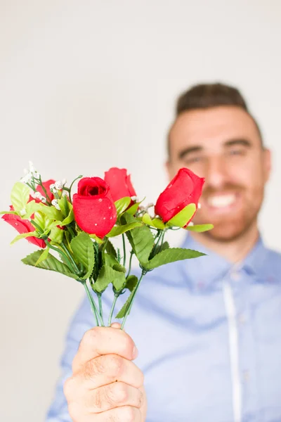 Mladý muž dává kytice růží — Stock fotografie