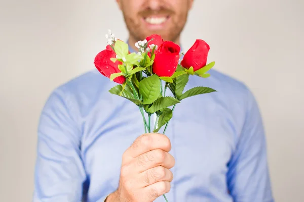 Jonge man die geeft een boeket rozen — Stockfoto