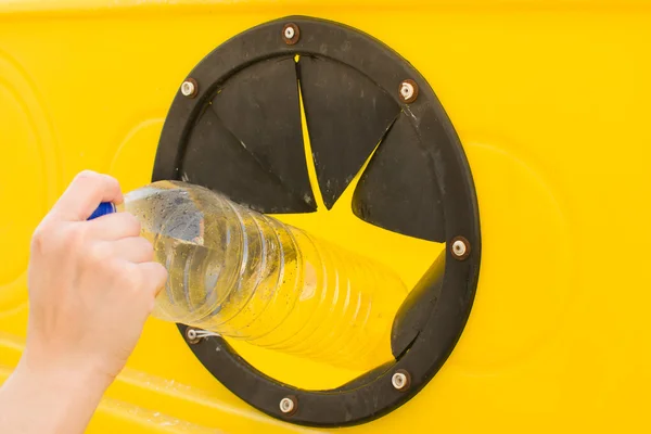 Lanzar una botella en el recipiente de reciclaje — Foto de Stock