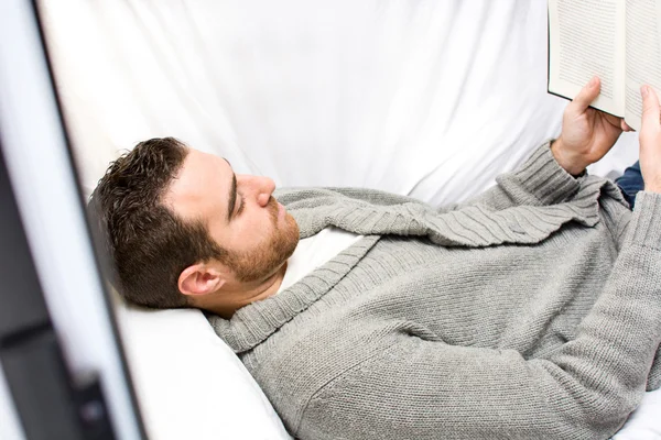 Young man reading on the sofa for your home — Stock Photo, Image