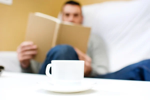 Young man reading on the sofa for your home — Stock Photo, Image