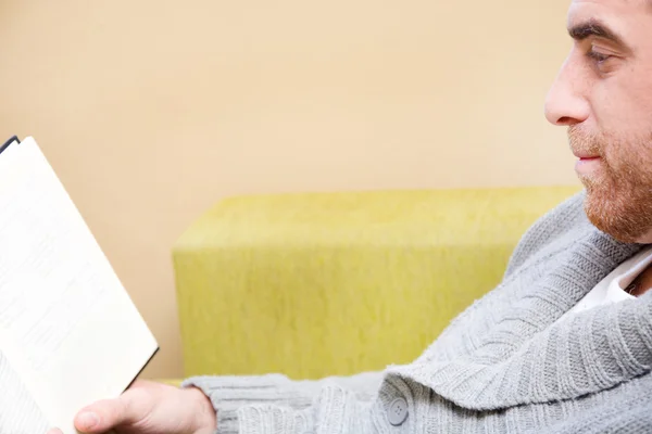 Young man reading on the sofa for your home — Stock Photo, Image