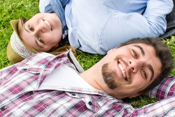 Ung man och ung kvinna ler i park — Stockfoto