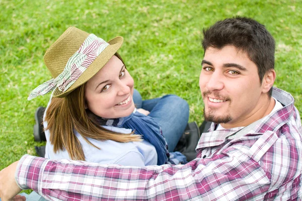 Молодой человек и молодая женщина улыбаются в парке — стоковое фото