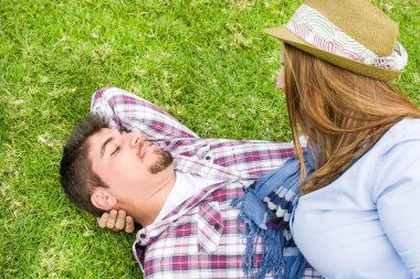 Genç adam ve genç kadın parkta gülümseyen