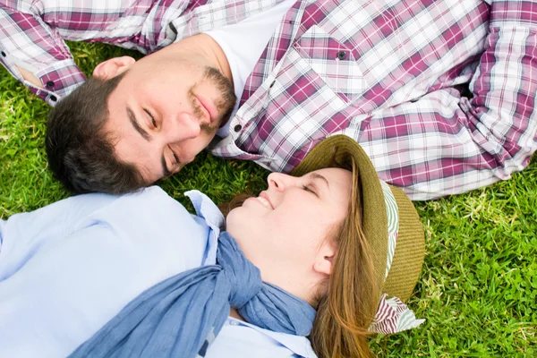 Ung man och ung kvinna ler i park — Stockfoto