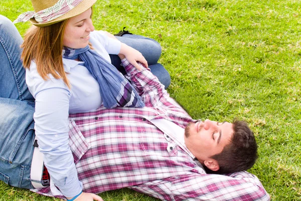 Молодой человек и молодая женщина улыбаются в парке — стоковое фото
