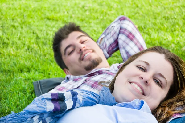 Par liggande i gräset i en park — Stockfoto