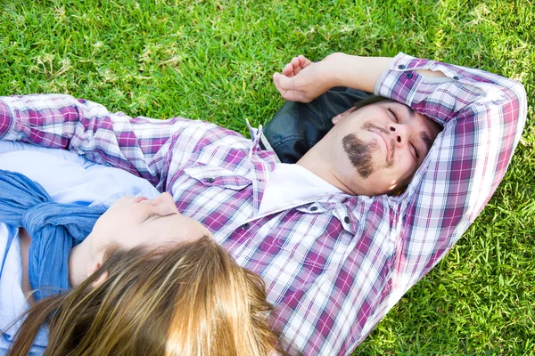 Пара лежащих на траве в парке — стоковое фото