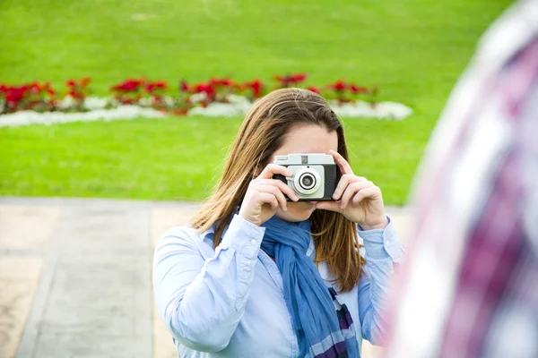 Giovane donna che fa una foto al suo ragazzo nel parco — Foto Stock