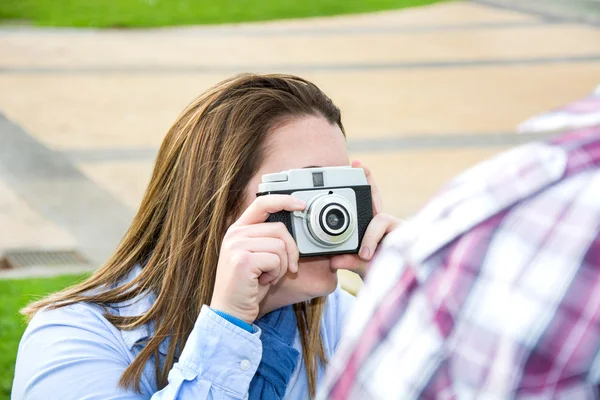 Giovane donna che fa una foto al suo ragazzo nel parco — Foto Stock